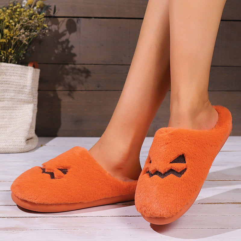 Side view of orange pumpkin slippers being worn