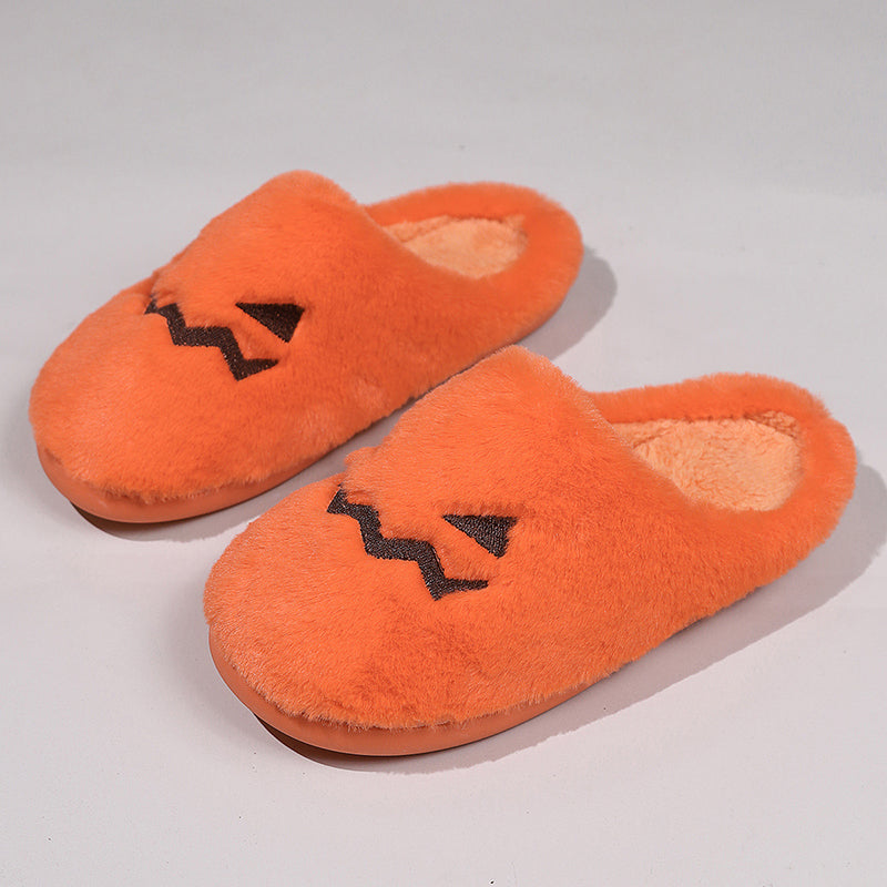 Angled view of orange jack-o'-lantern slippers