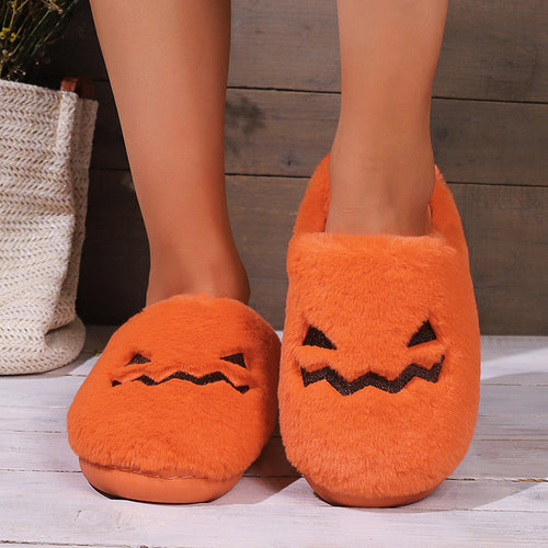 Orange jack-o'-lantern plush slippers worn indoors